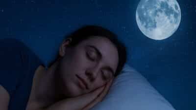 Une femme endormie sur un oreiller, sous un ciel étoilé avec la pleine lune.